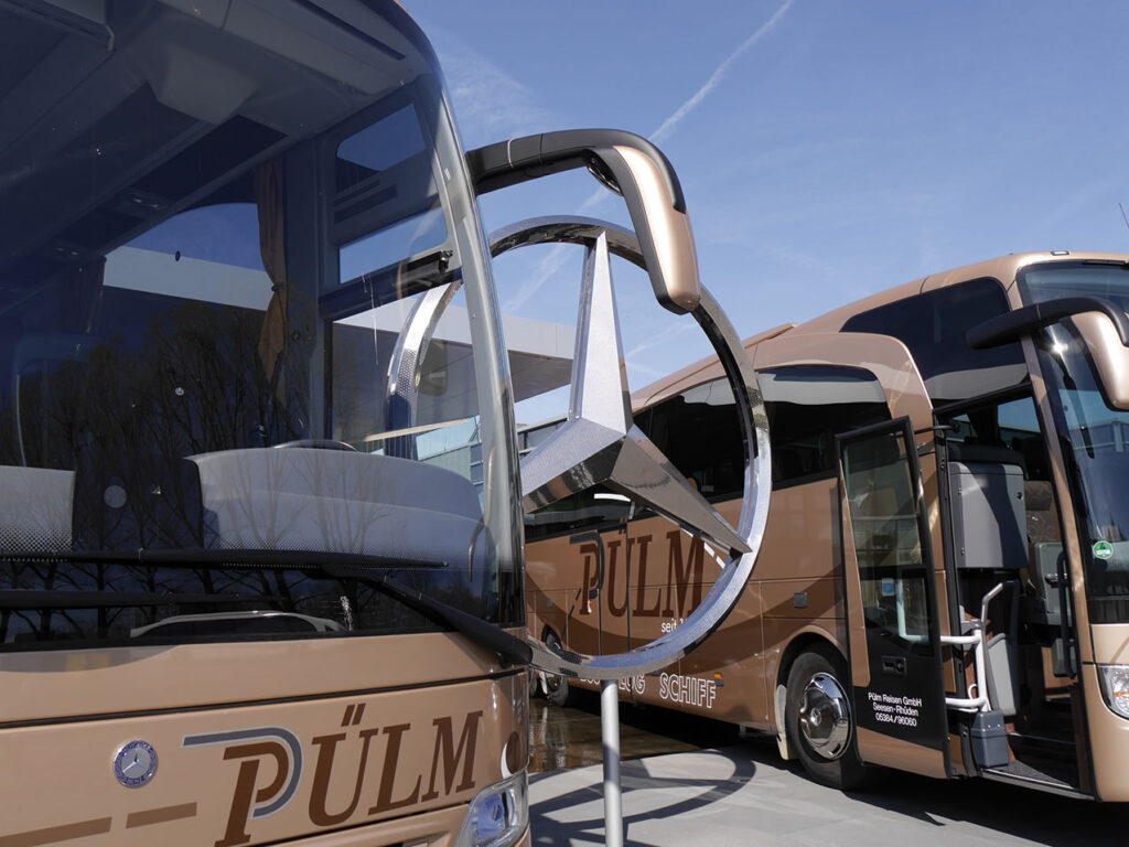 Nahaufnahme von zwei Reisebussen der Firma Pülmreisen.