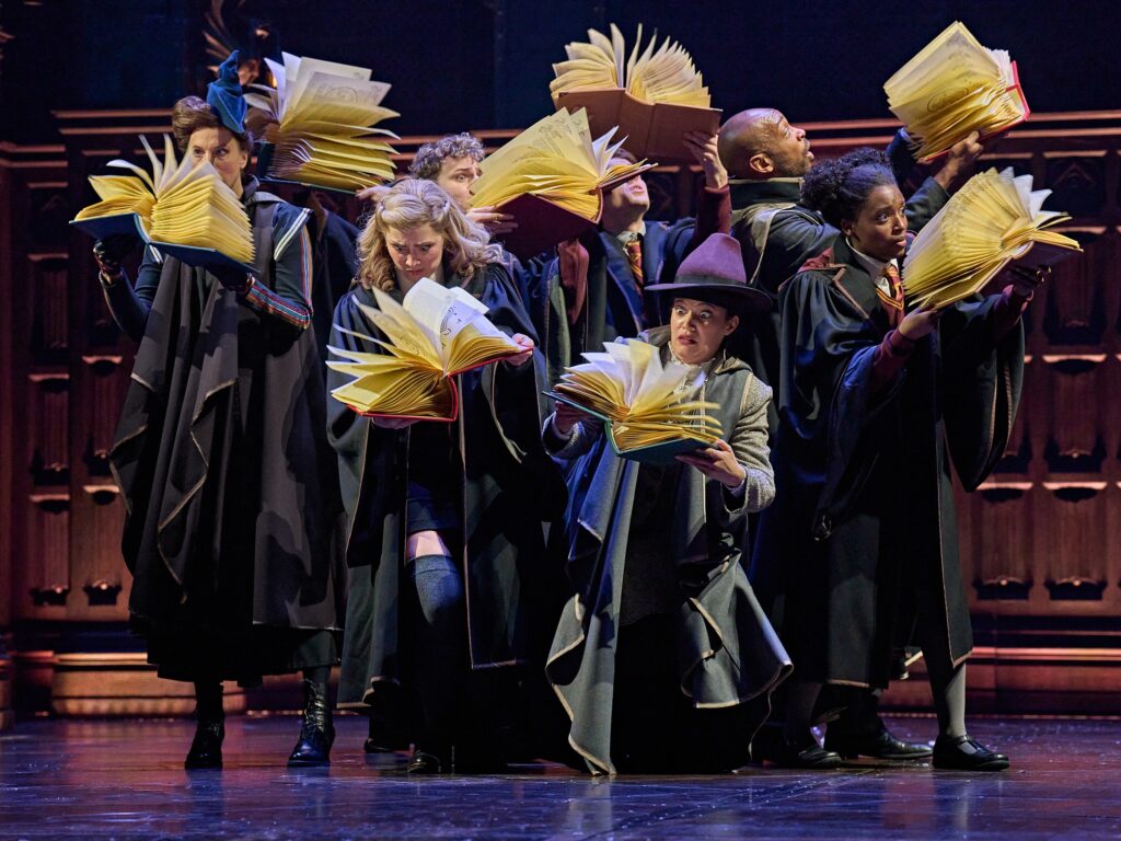 Szene aus dem Musical Harry Potter. Schüler lesen in Zauberbüchern.