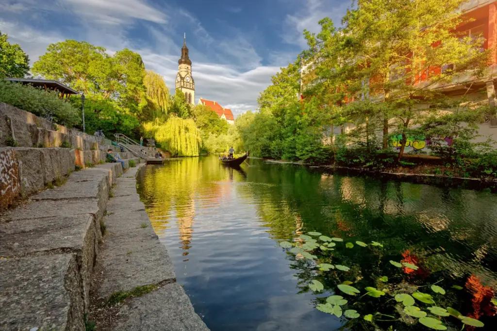 Blick vom Wasser auf einen Kanal mit Gondel in Leipzig.