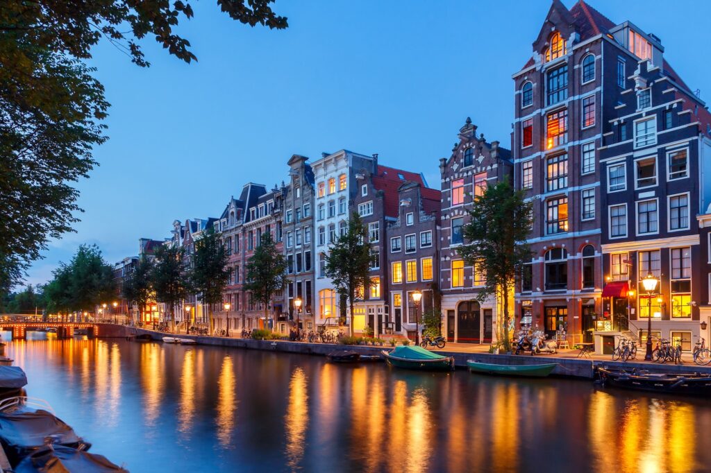 Blick auf die Abendlichter in einer Gracht in Amsterdam.