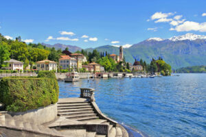 Die Stadt Tremezzo am Comer See in Italien mit einer Steintreppe zum See im Vordergrund.