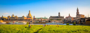 Blick von einer Wiese an der Elbe auf das Stadtpanorama von Dresden.