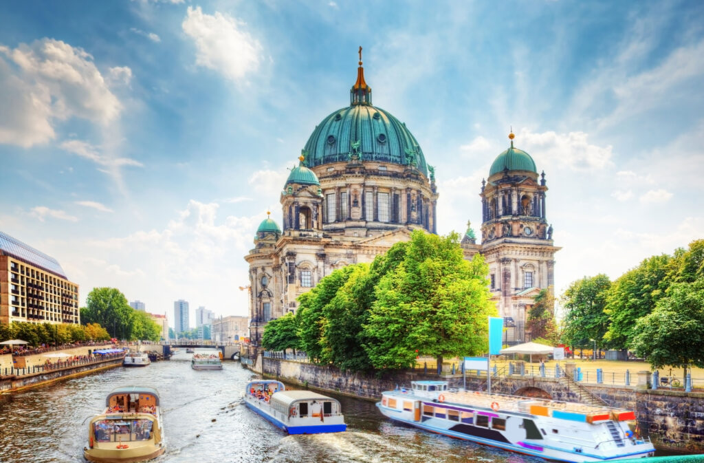 Blick auf die Museumsinsel in Berlin mit Booten auf dem Wasser im Vordergrund.
