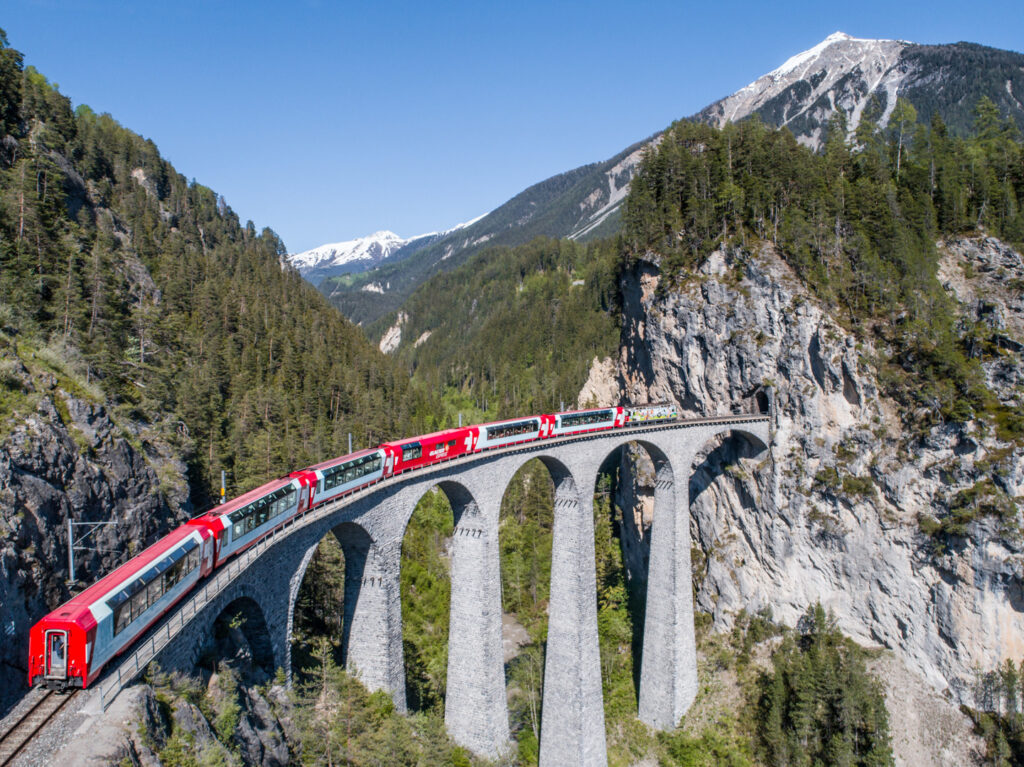 Der Bernina Express fährt auf dem Landwasser Viadukt in den Schweizer Alpen.