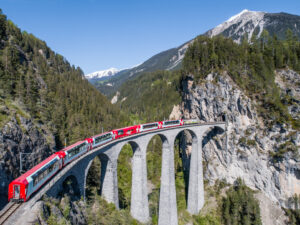 Der Bernina Express fährt auf dem Landwasser Viadukt in den Schweizer Alpen.