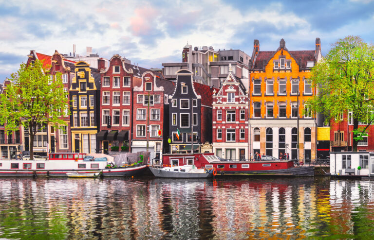Blick vom Wasser auf eine Häuserfront in einer Gracht in Amsterdam.
