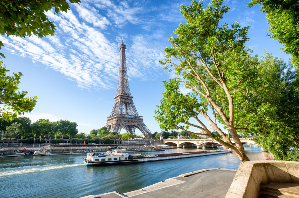 Der Eiffelturm in Paris, davor eine Boot auf der Seine.