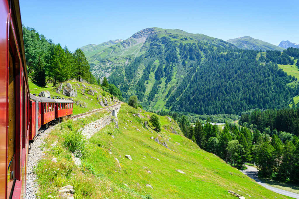 Eine Dampfeisenbahn fährt durch die Schweizer Alpen in der Region Furka.