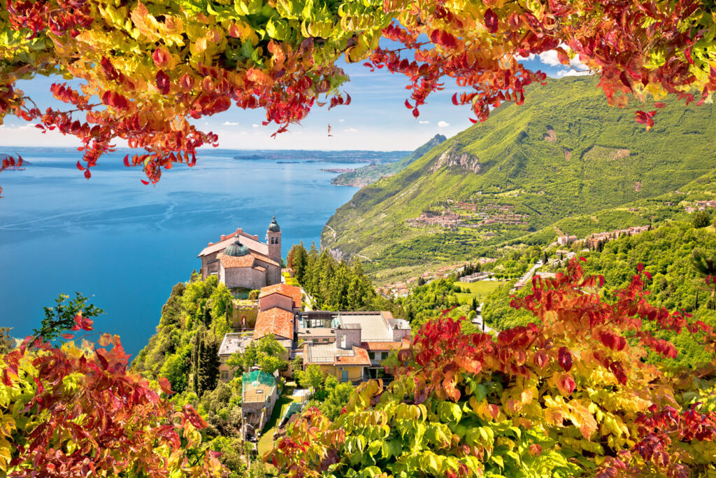 Blick von oben auf Madonna di Montecastello am Gardasee mit herbstlichem Laub im Vordergrund.