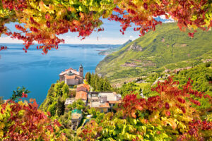 Blick von oben auf Madonna di Montecastello am Gardasee mit herbstlichem Laub im Vordergrund.
