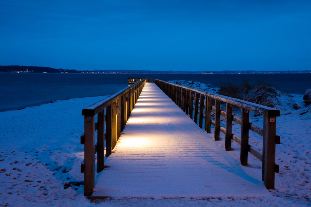 Ein Steg im winterlichen Sonnenuntergang am Timmendorfer Strand.